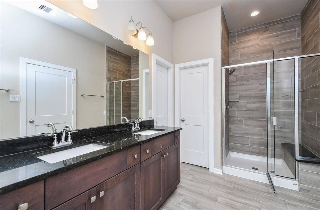 The master bathroom offers a sleek and modern design, featuring a spacious glass-enclosed standing shower with elegant tile accents. A stylish vanity with ample counter space and contemporary fixtures provides both functionality and sophistication. Soft lighting and a neutral palette create a serene, spa-like retreat.