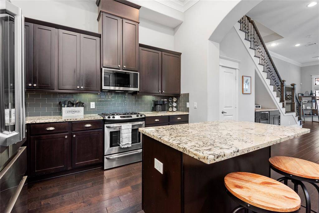 A spacious kitchen equipped with a gas range and stainless steel appliances, perfect for culinary enthusiasts.