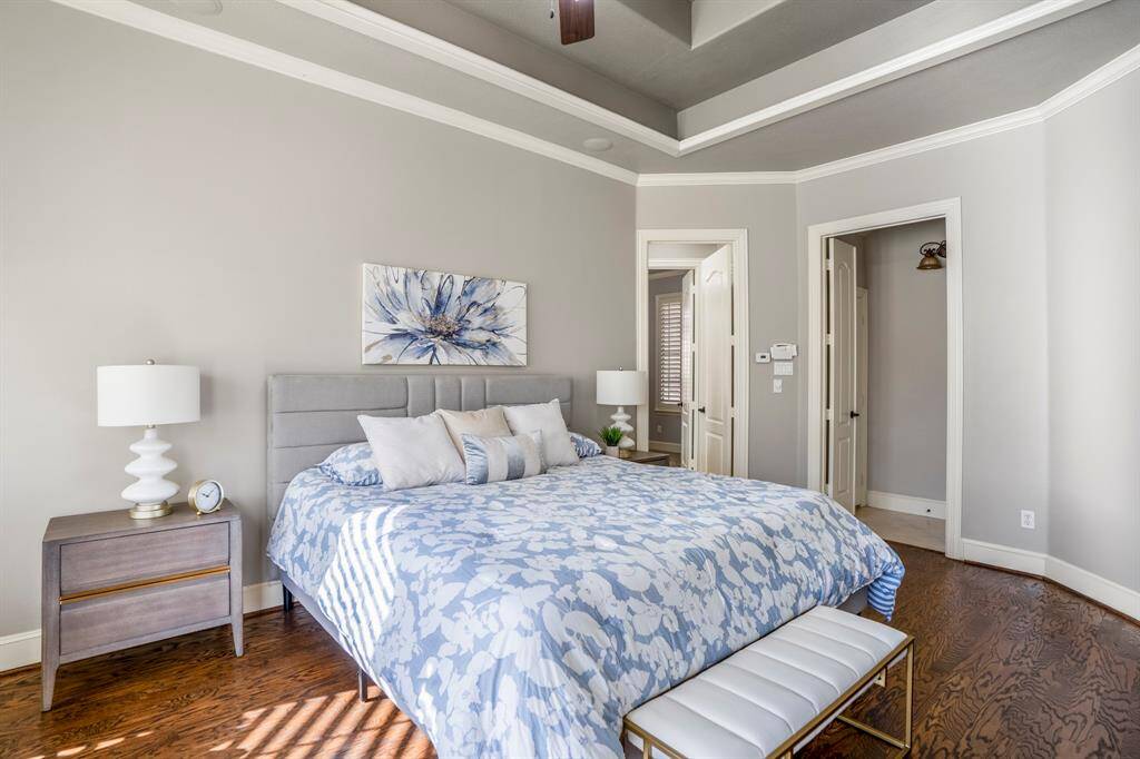 The primary suite offers beautiful oak wood floors, plantation shutters and wide baseboards and paneled doors as well as a door out onto the patio to enjoy a morning cup of coffee or an evening cocktail.
