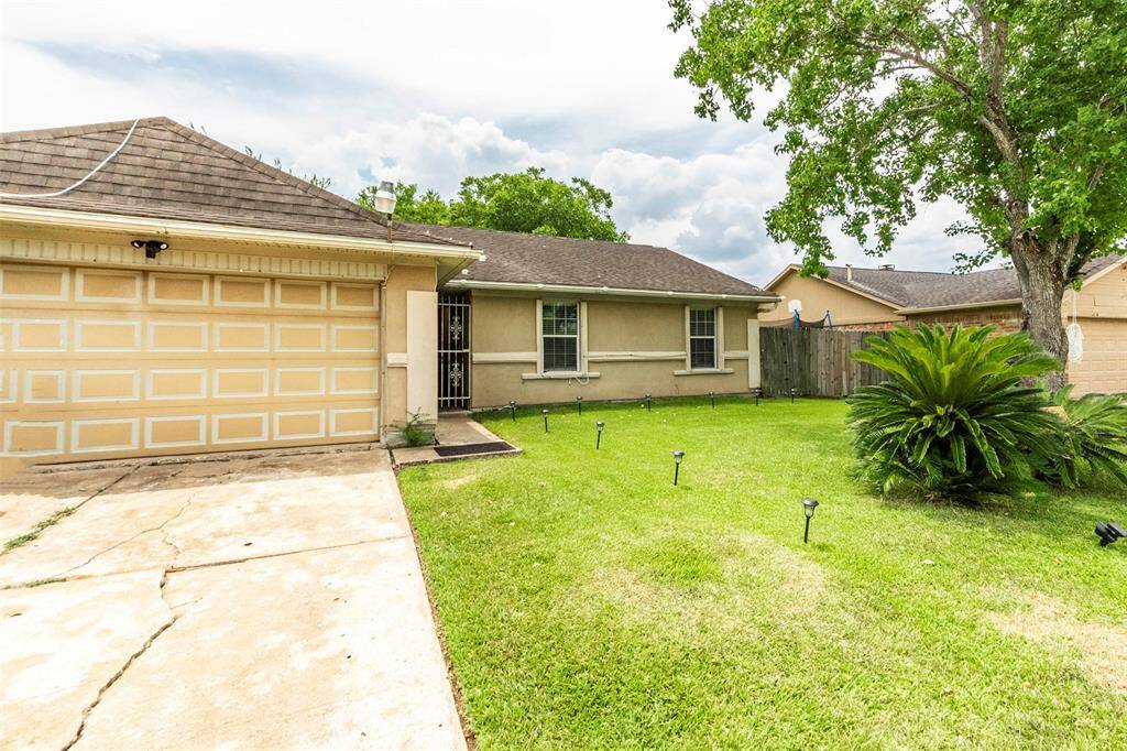 Charming single-story home with a two-car garage, well-maintained front yard, and mature trees.