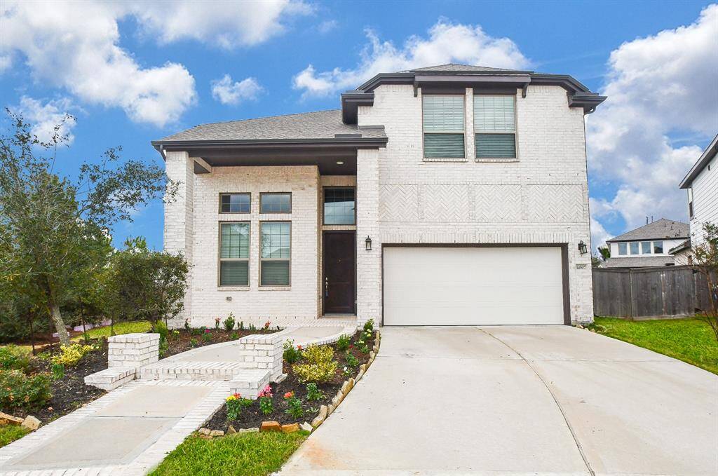 This modern two-story brick home features a clean exterior with a large garage, beautifully landscaped front yard, and a welcoming pathway leading to the entrance. Perfect for families seeking a contemporary, spacious living space in a well-maintained neighborhood.