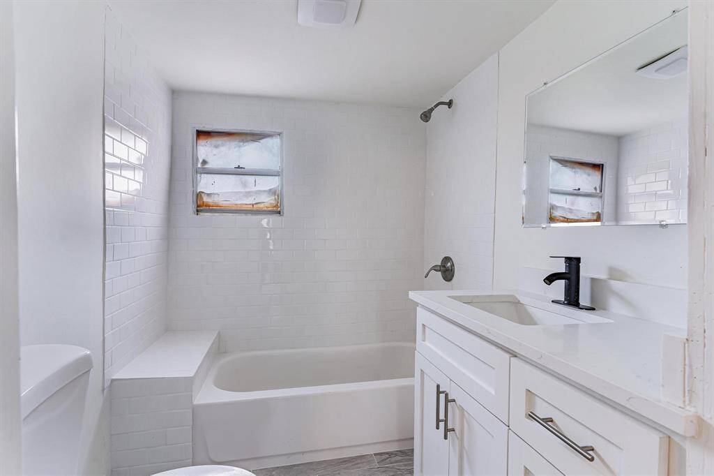 Stunningly remodeled bathroom featuring custom cabinets, elegant fixtures, and a sleek shower.