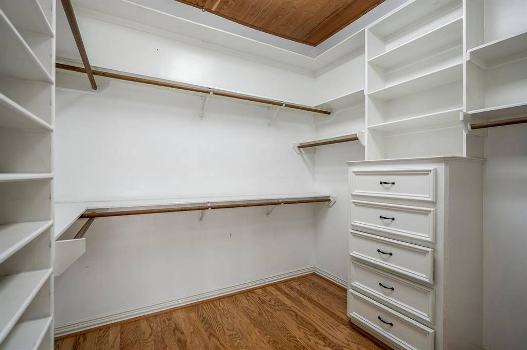 This is the second closet in the primary bedroom suite, offering everything you could possible need for storage, including wood flooring and ceiling.