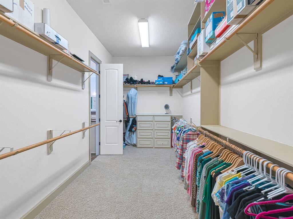 Enormous His & Her closets in the primary bedroom with built-in cabinetry