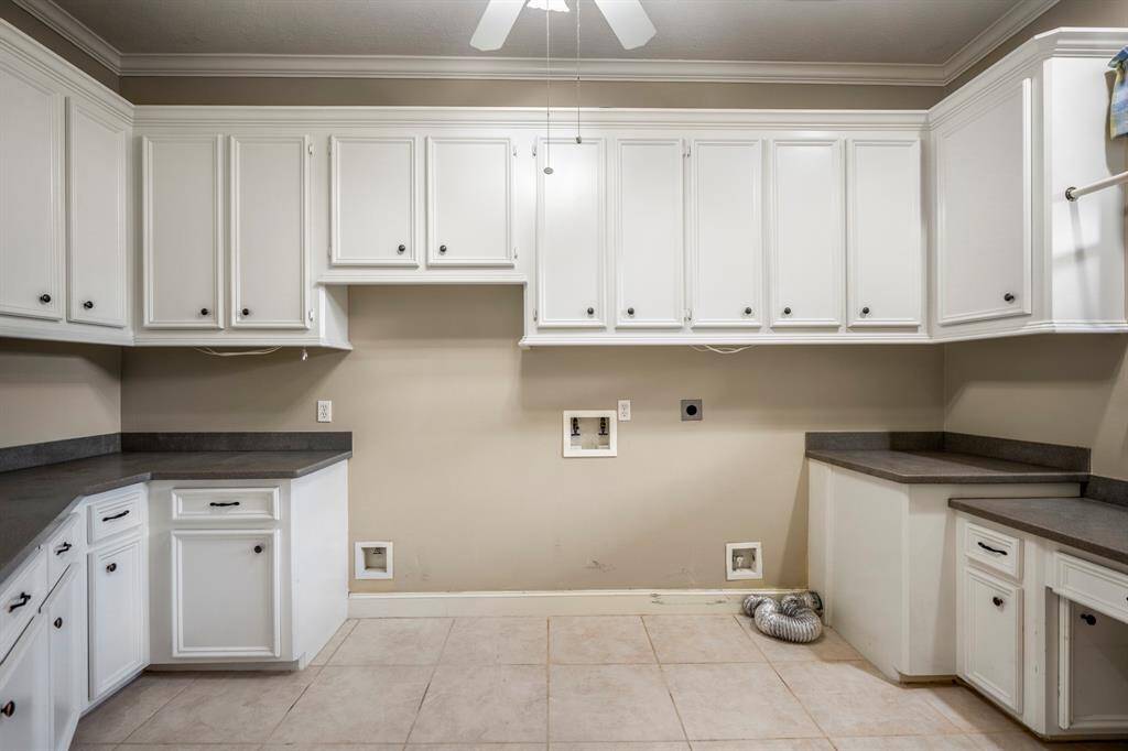 The laundry room is huge and offers so much space for a washer, dryer, refrigerator as well as a desk area, and tons of cabinetry, folding areas and more.