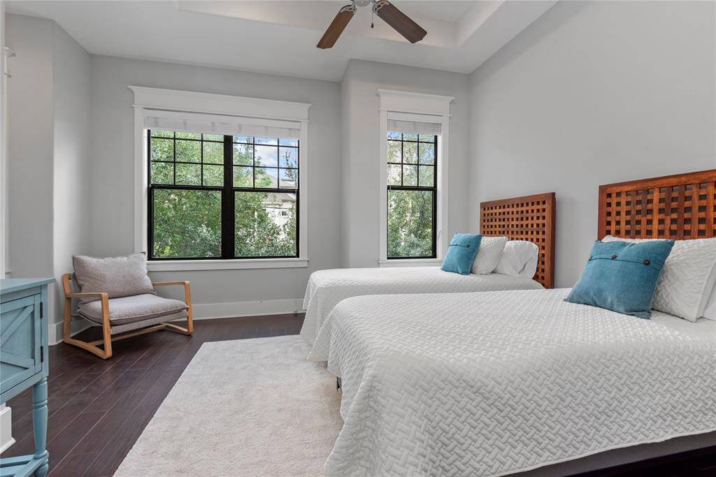 A spacious second bedroom with large windows and tasteful decor.