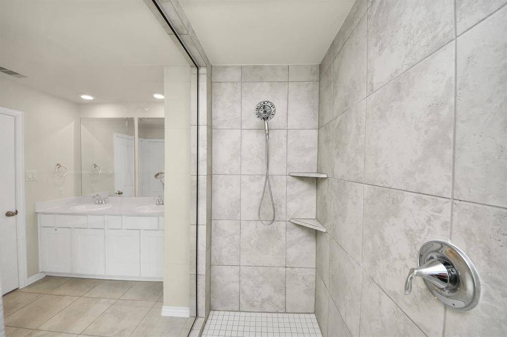 Primary bathroom with dual sinks and walk in shower.