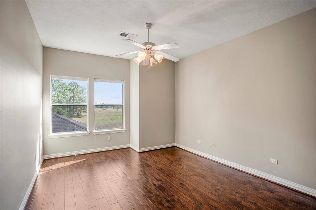 This home has 5 bedrooms, 4.5 bathrooms, and this is the fourth bedroom upstairs offering beautiful flooring, a lighted ceiling fan, and views of the golf course.