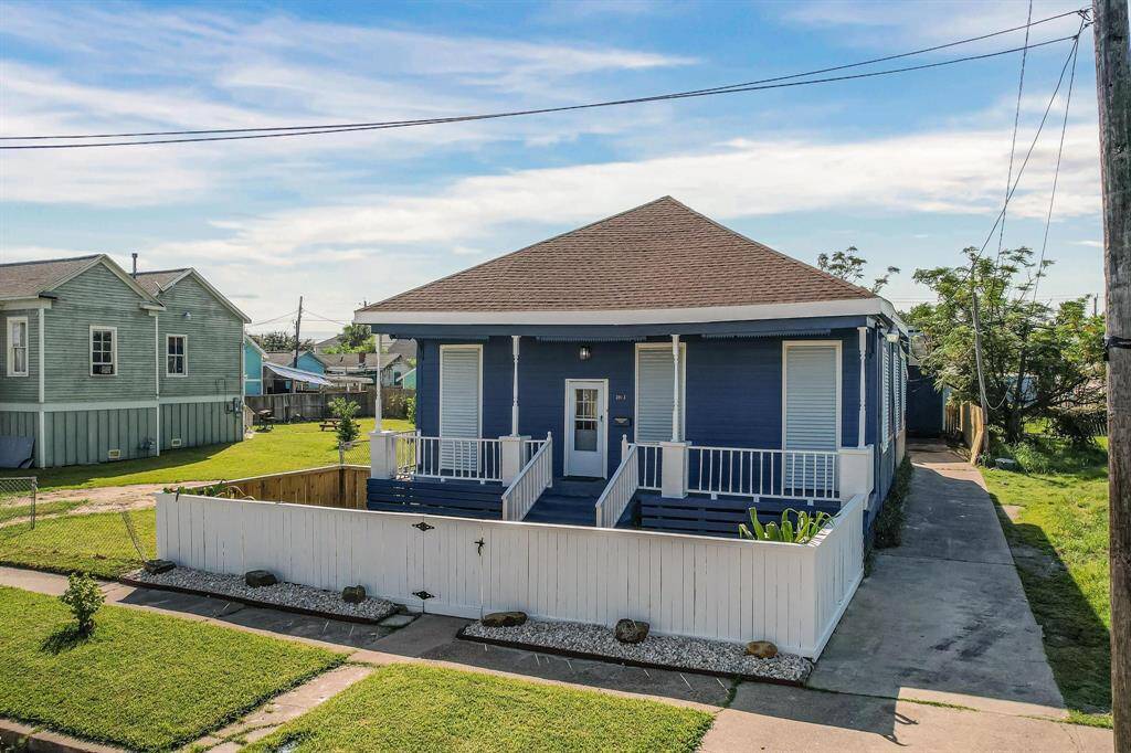 This charming blue bungalow features a wrap-around porch and a neatly fenced front yard. It has a spacious driveway and is set in a quiet neighborhood with well-maintained lawns. Perfect for those seeking a cozy, inviting home.