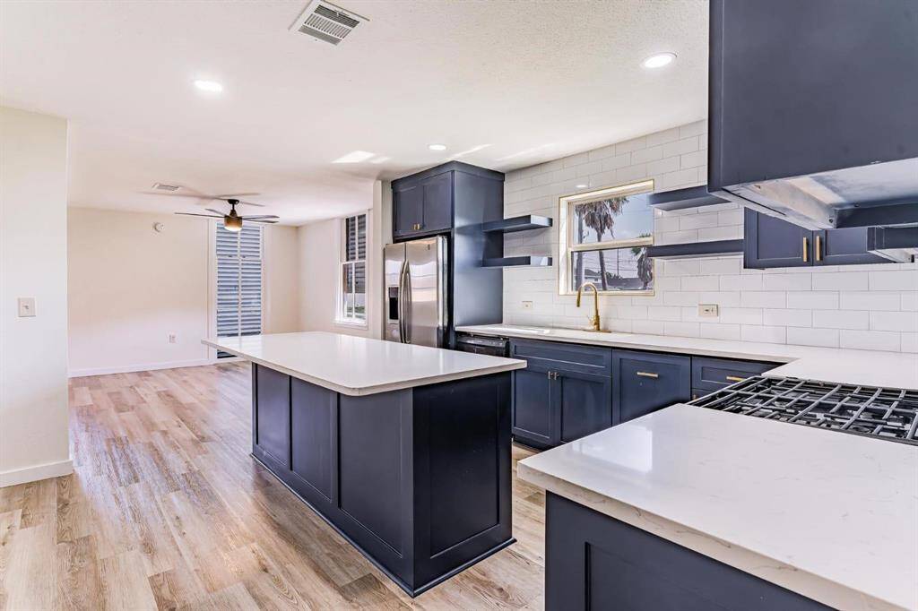This stunning kitchen features a complete remodel with new floors, elegant countertops, custom cabinets, and modern appliances.
