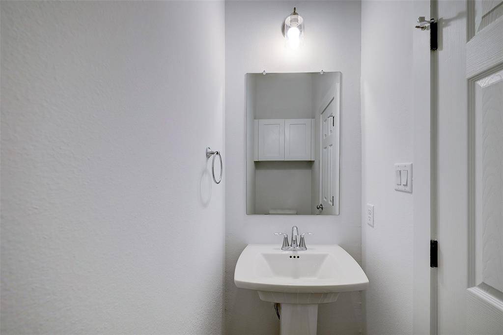 A well-executed powder room is tucked away from sight but easily accessible to guests and residents. A storage cabinet is placed above the commode for convenience.