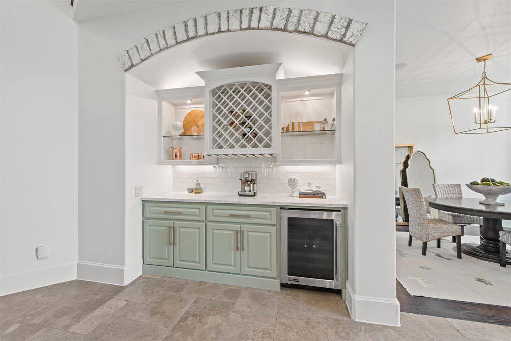 Bar/coffee station with quartz counter and wine fridge upon entry.
