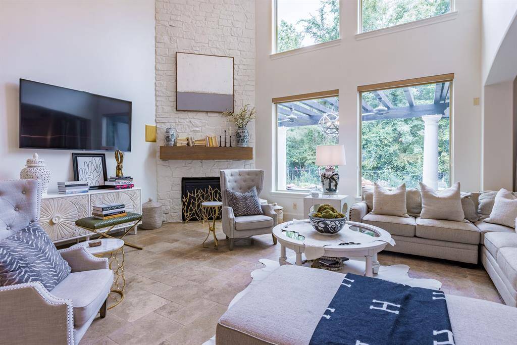 Floor to ceiling painted stoned fireplace, and stained wood beam mantel brings warmth to the space.
