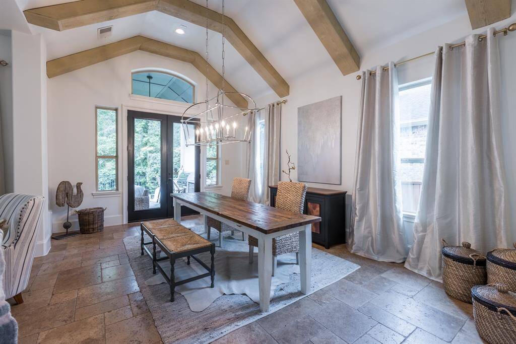 Painted beams, with double doors leading out to back patio/outdoor kitchen space.