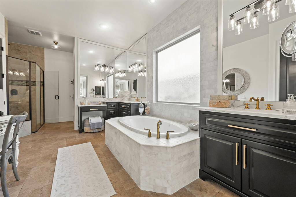 Remodeled primary bath with marble tile on decking and back wall.  Painted cabinets and hardware
