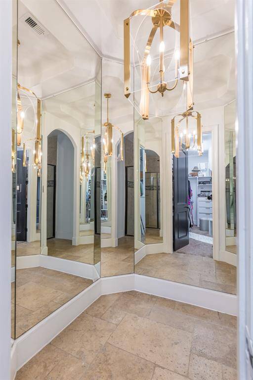 Full mirrored clothing try on area outside of closet with accent chandelier!