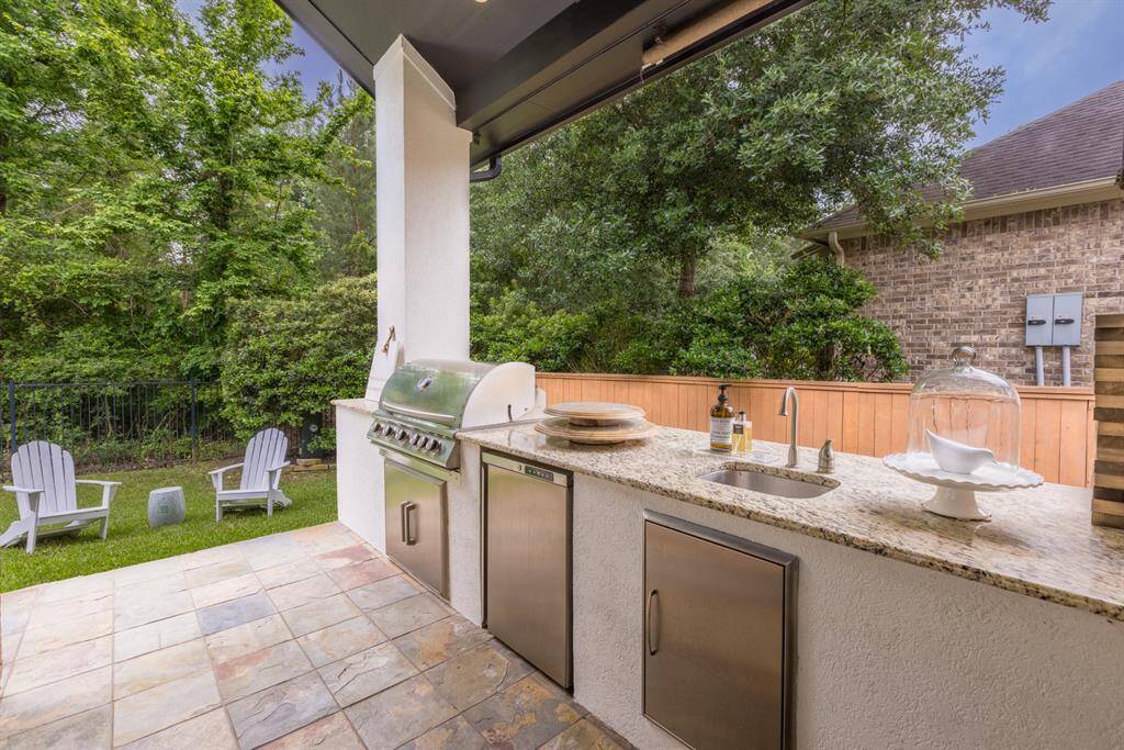 Covered outdoor kitchen with grill, mini fridge and sink
