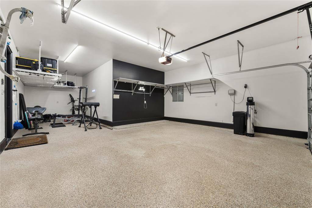 Three car tandem garage accompanied by epoxy garage floors and overhead ceiling storage.