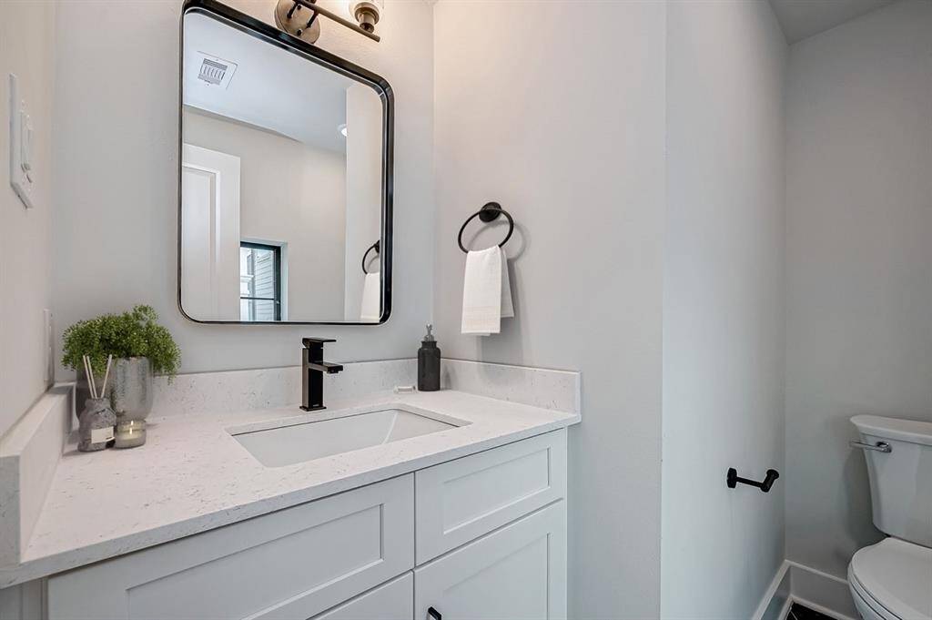 This modern bathroom features a spacious glass-enclosed shower, a freestanding bathtub, and a sleek vanity with ample storage. The neutral tiles and contemporary fixtures create a clean and elegant look.