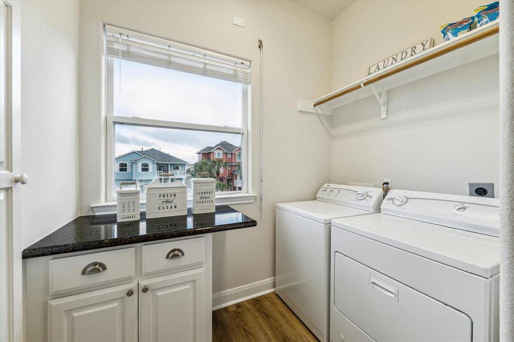 Laundry has hanging drying bar, convenient countertop and cabinets. A laundry room with a pretty view