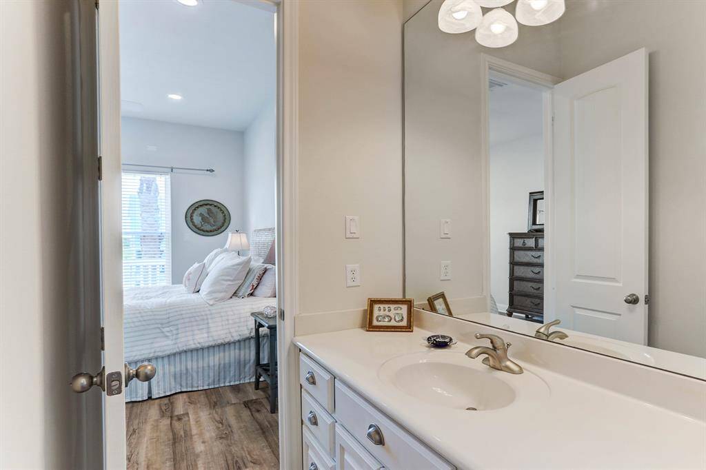 Jack and Jill bath connects to both downstairs bedrooms and features two dressing areas,