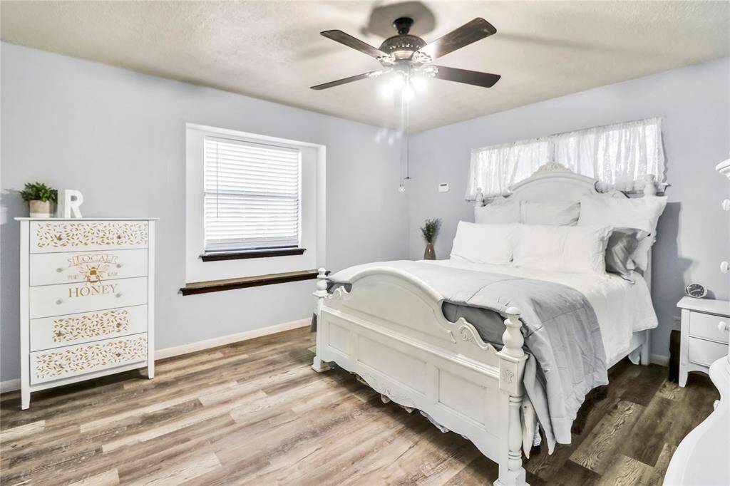 Spacious primary bedroom featuring lament flooring and abundant natural light.