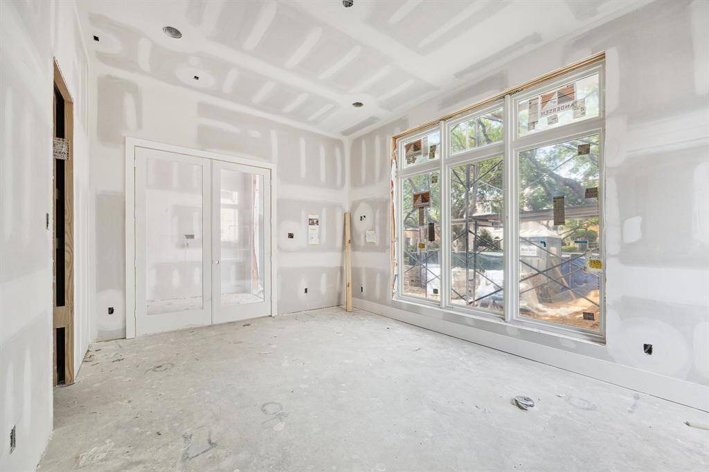 Study off the entrance of the home with beautiful paneled walls. The Study also features a Pendant Light, a set of Clear Glass Doors, a Closet and access to a Full Bath.