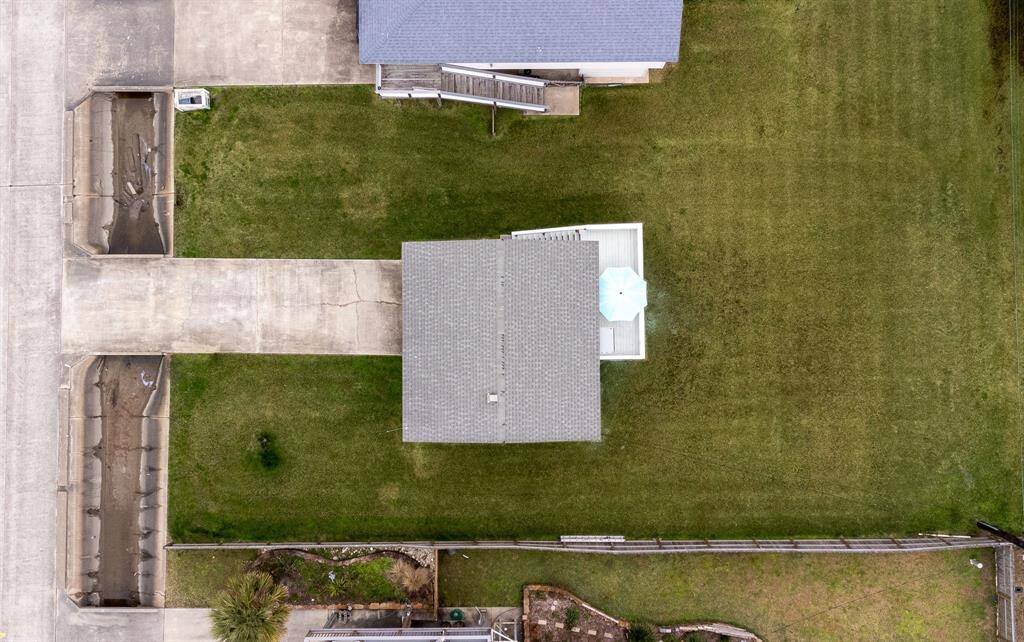 This photo showcases a coastal neighborhood with a highlighted property featuring a cozy, coastal home. Spacious yard, and close proximity to the water, ideal for beach lovers seeking a serene residential setting.