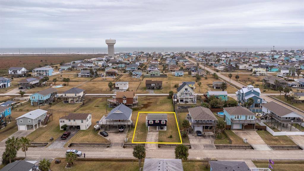 This photo showcases a coastal neighborhood with a highlighted property featuring a cozy, coastal home. Spacious yard, and close proximity to the water, ideal for beach lovers seeking a serene residential setting.