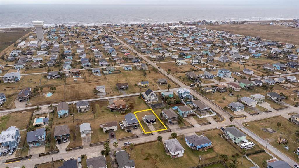 This photo showcases a coastal neighborhood with a highlighted property featuring a cozy, coastal home. Spacious yard, and close proximity to the water, ideal for beach lovers seeking a serene residential setting.