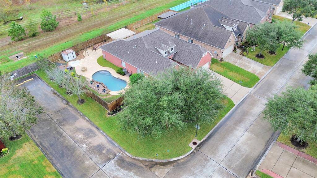 Nestled in a peaceful neighborhood, this property features a fenced backyard with a sparkling pool, fire pit, and inviting patio, surrounded by lush, mature trees and a pristine lawn. Enjoy adjacent green space for added tranquility.