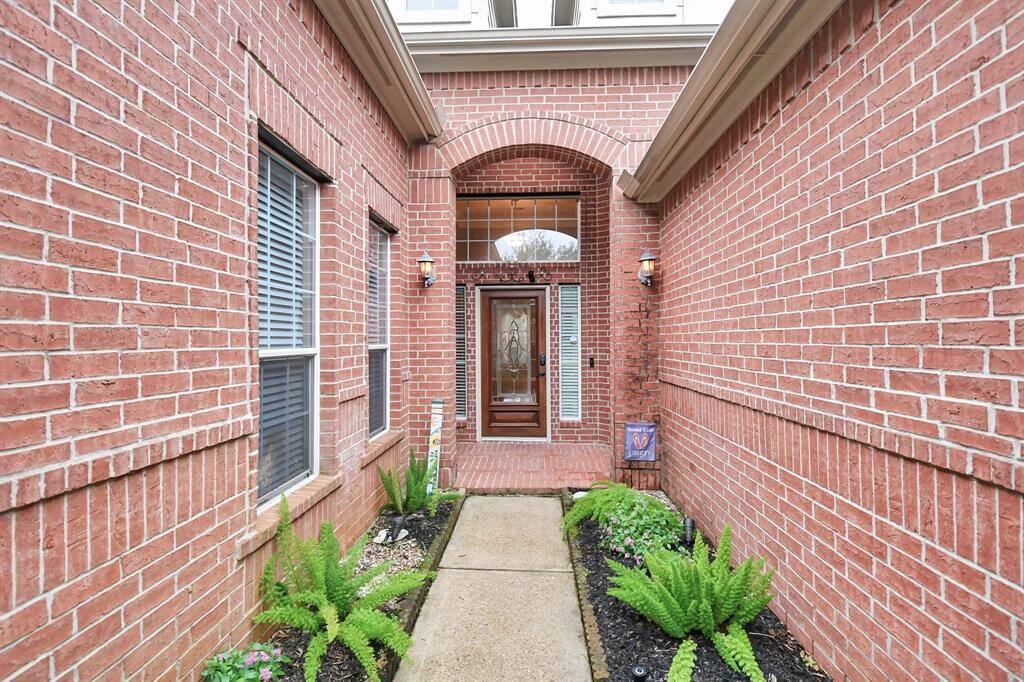 Charming brick home with stunning curb appeal and lush, manicured landscaping.