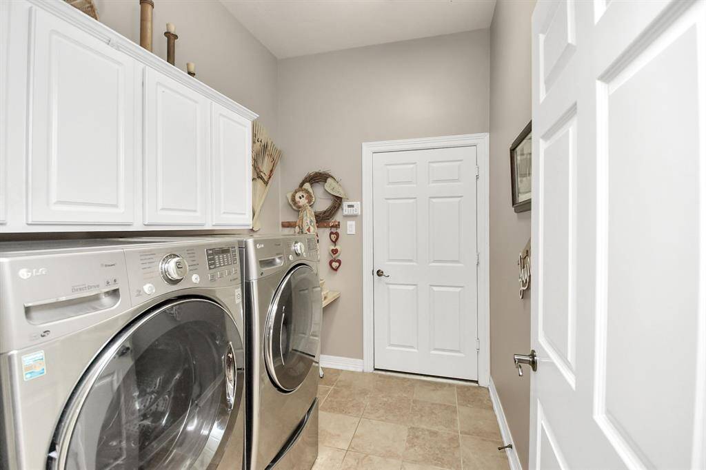 Spacious laundry room with cabinetry nestled between the garage and kitchen.  Washer and Dryer stay with the home.