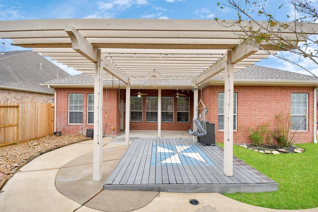 Enjoy outdoor living in this backyard oasis with a pergola, patio fans, a sparkling pool, and a cozy fire pit, all conveniently located off the kitchen and breakfast area.