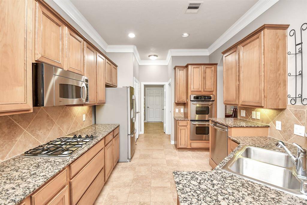 Virtually Staged - Luxurious primary bedroom with engineered wood flooring, leading to a spacious bathroom suite and expansive walk-in closet.