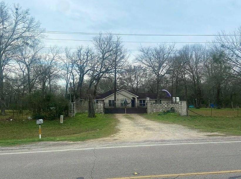This property features a charming single-story home set back from the road, surrounded by mature trees. It has a gated entrance with a driveway and a spacious front yard, offering privacy and a serene atmosphere. It is ideal for buyers seeking a peaceful, natural setting.