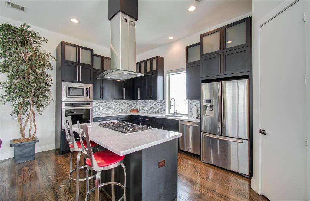 Large island with extra seating, gas cooktop, and so much space to gather here in the kitchen.
