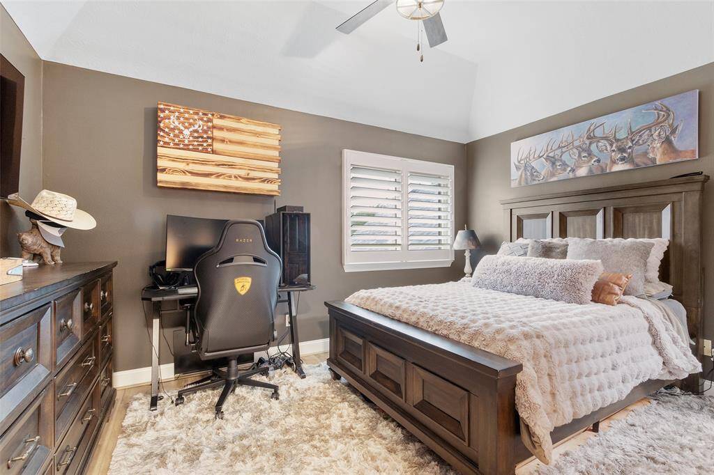 One of the upstairs bedrooms that features wood floors, modern ceiling fan & great closet space with built in dressers.