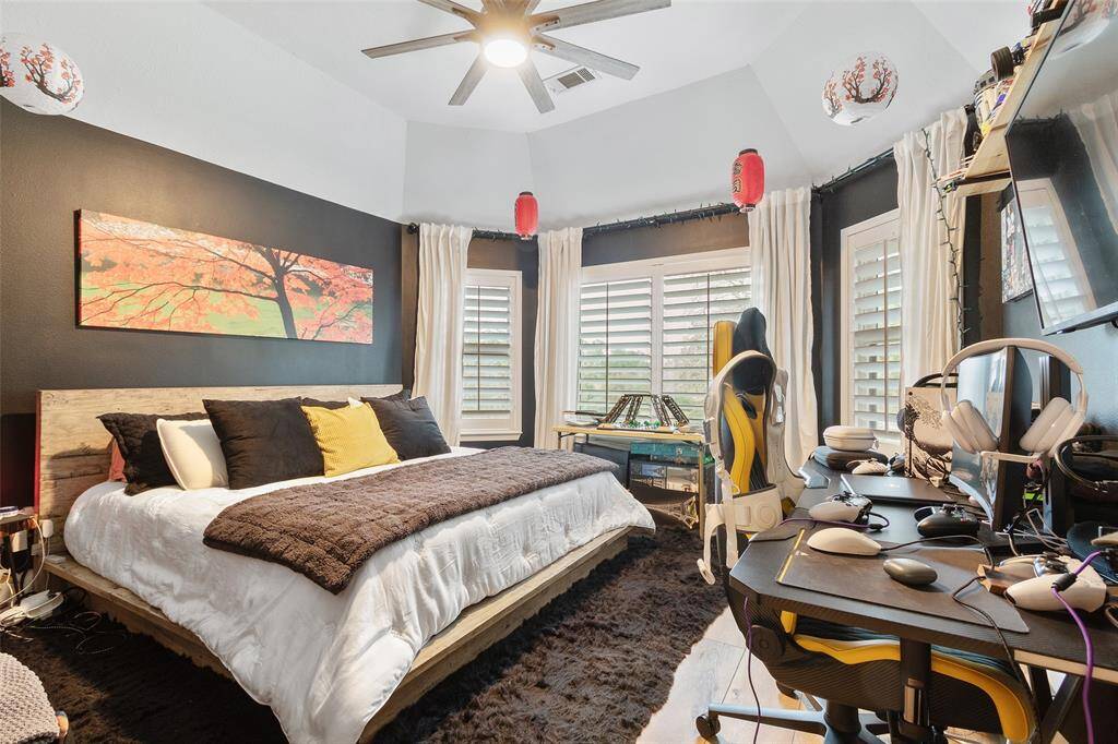 Large upstairs bedroom with plantation shutters, ceiling fan, wood floors & good closet space.