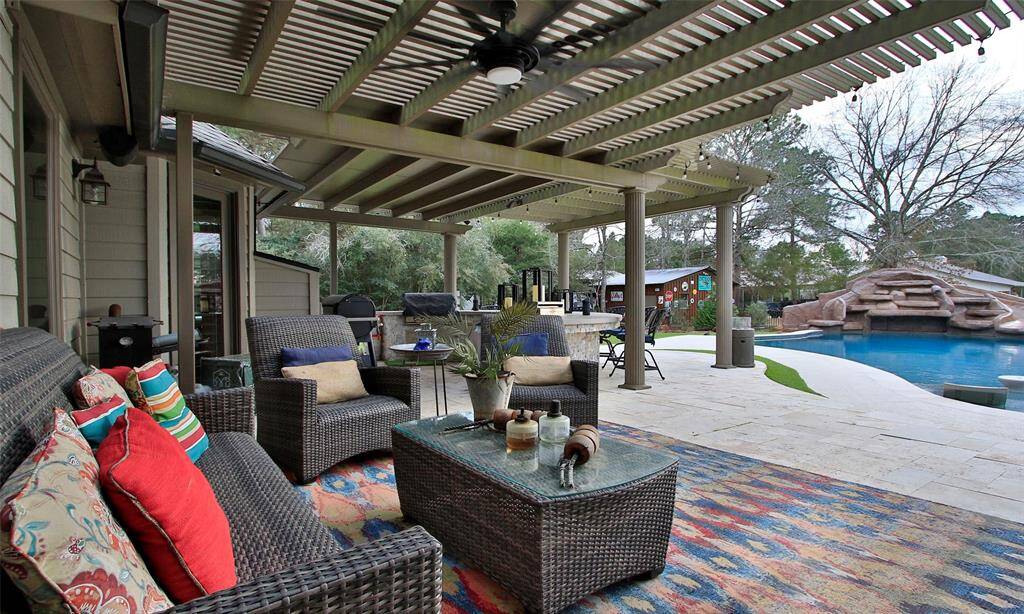This photo showcases a spacious backyard with a pergola covered patio with plenty of room for your outdoor furniture. This serene outdoor living space is perfect for relaxation and entertaining.
