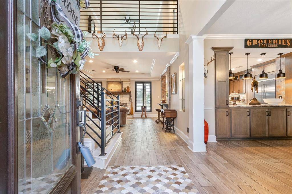 This inviting home features a warm, open entryway leading to a cozy living area with a stone fireplace. Beautiful engineered wood floors, high ceilings and a balcony add spaciousness, creating a welcoming atmosphere.