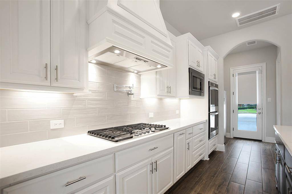 This kitchen is a culinary enthusiast's paradise, featuring a top-of-the-line 36-inch gas cooktop with a convenient pot filler, making it easier than ever to prepare meals with precision and ease. The double convection ovens allow for even cooking and versatility, perfect for everything from holiday feasts to daily meals.