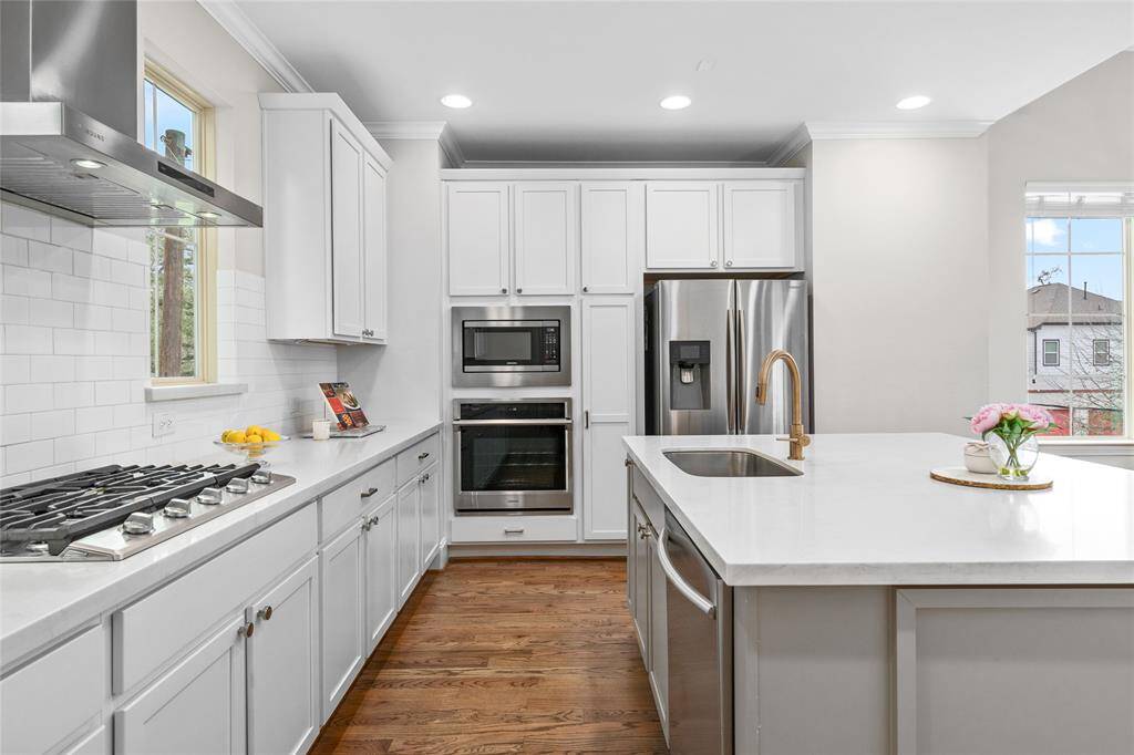 Cooking and baking in this well-illuminated kitchen offering LED flush mount recessed lights. The stainless island sink is directly across from the cooktop and perpendicular to the microwave, oven and refrigerator. Note: the refrigerator is not buil-in and is excluded from the sale.