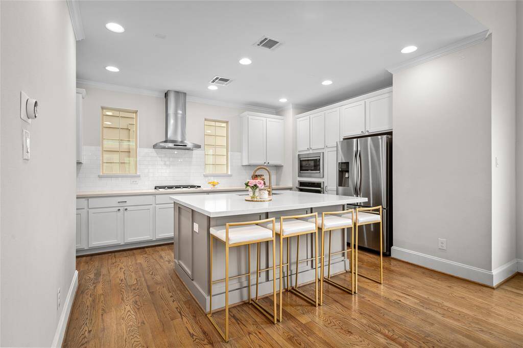 This thoughtful design includes a pair of symmetrical windows on either side of the vent hood and cooktop. Install your favorite framed art on the floor-to-ceiling walls.
