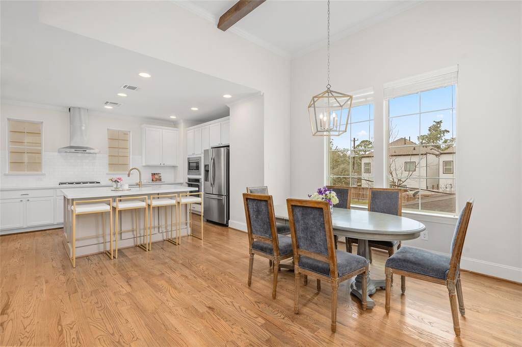 This wide shot photo of both the quartz island kitchen and the dining niche shows off the side-by-side double pane windows.