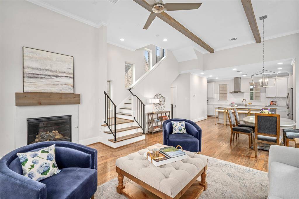 This angle depicts the architectural interest  of this grand space [17' x 13']. The iron and wood staircase to the third floor, oak ceiling beams, recessed fireplace, hearth and mantle and bonus ceiling fan are most impressive.