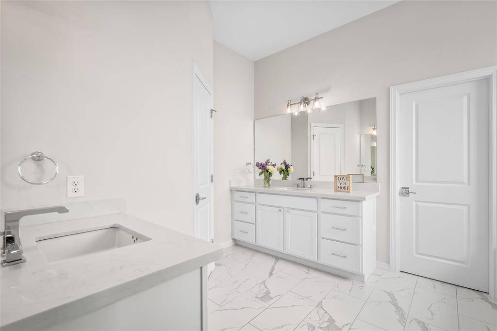 The primary bathroom includes two separate vanities with sconce lighting.