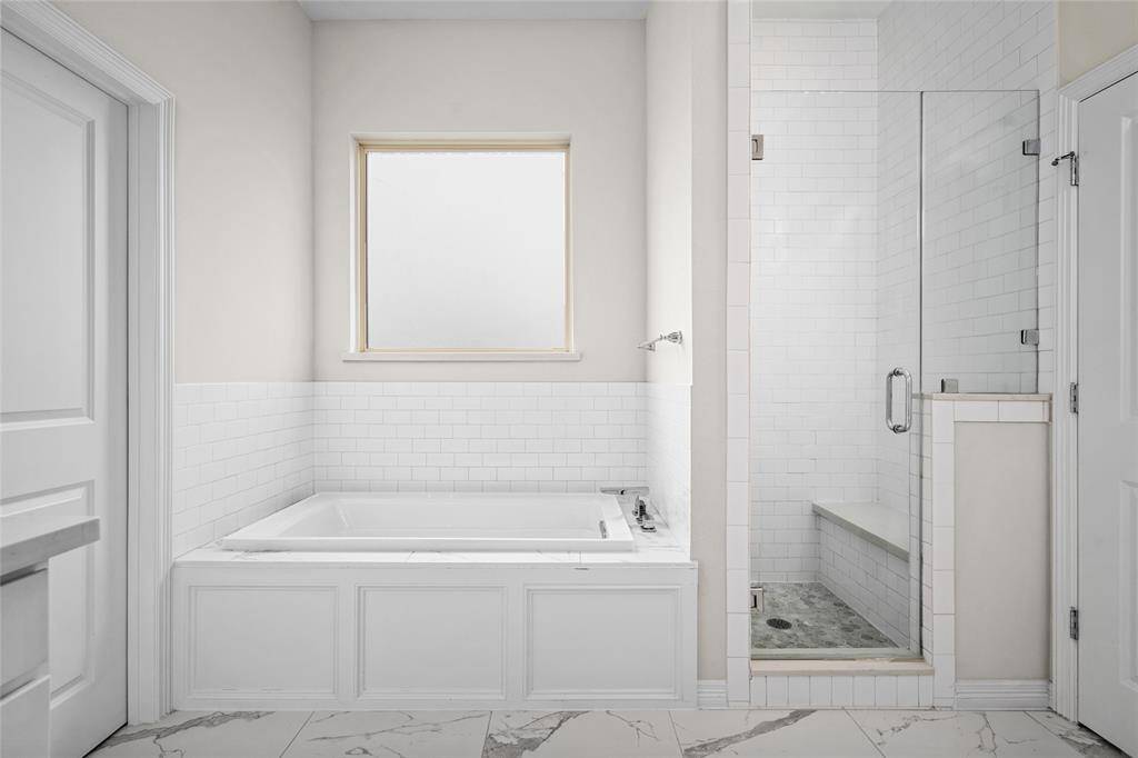 Photo of both the soaking tub and separate shower in the primary bath.