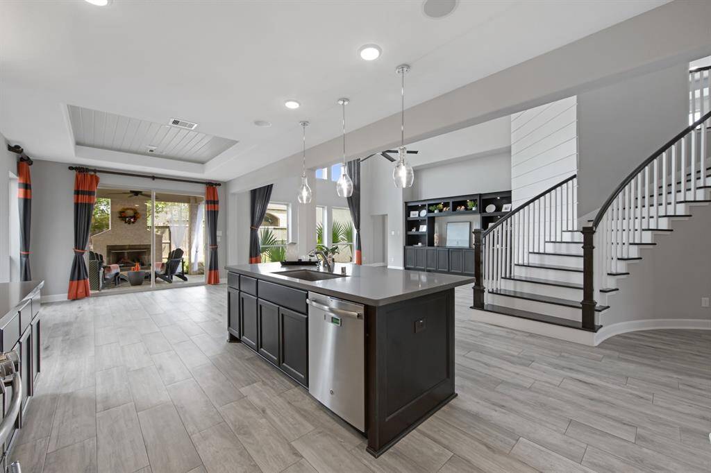 The kitchen countertops are Silestone. The island has a stainless steel Energy Star Dishwasher and a Jasper Stainless Steel Single Bowl Under Mount Sink with a chrome Moon pullout spout faucet and garbage disposal.  There are 3 glass pendant lights above the island in addition to canned lights to provide abundant lighting.  There are two built in ceiling speakers (located on the outer edges of the island lights).