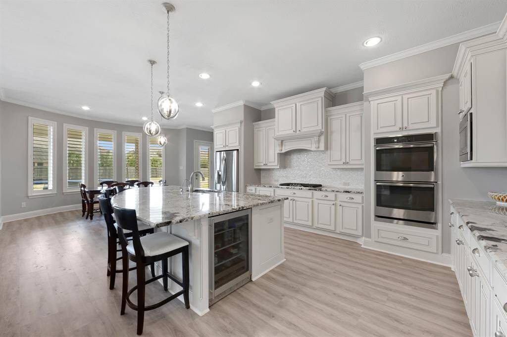 The gorgeous island kitchen is a chef’s dream, featuring sleek granite countertops that provide both beauty and durability. Double ovens offer ample cooking space for preparing large meals, while the stainless steel appliances add a modern, polished touch. With an abundance of cabinetry, there’s no shortage of storage, keeping the space organized and efficient. The large island serves as both a prep area and a gathering spot, making it the heart of the home.